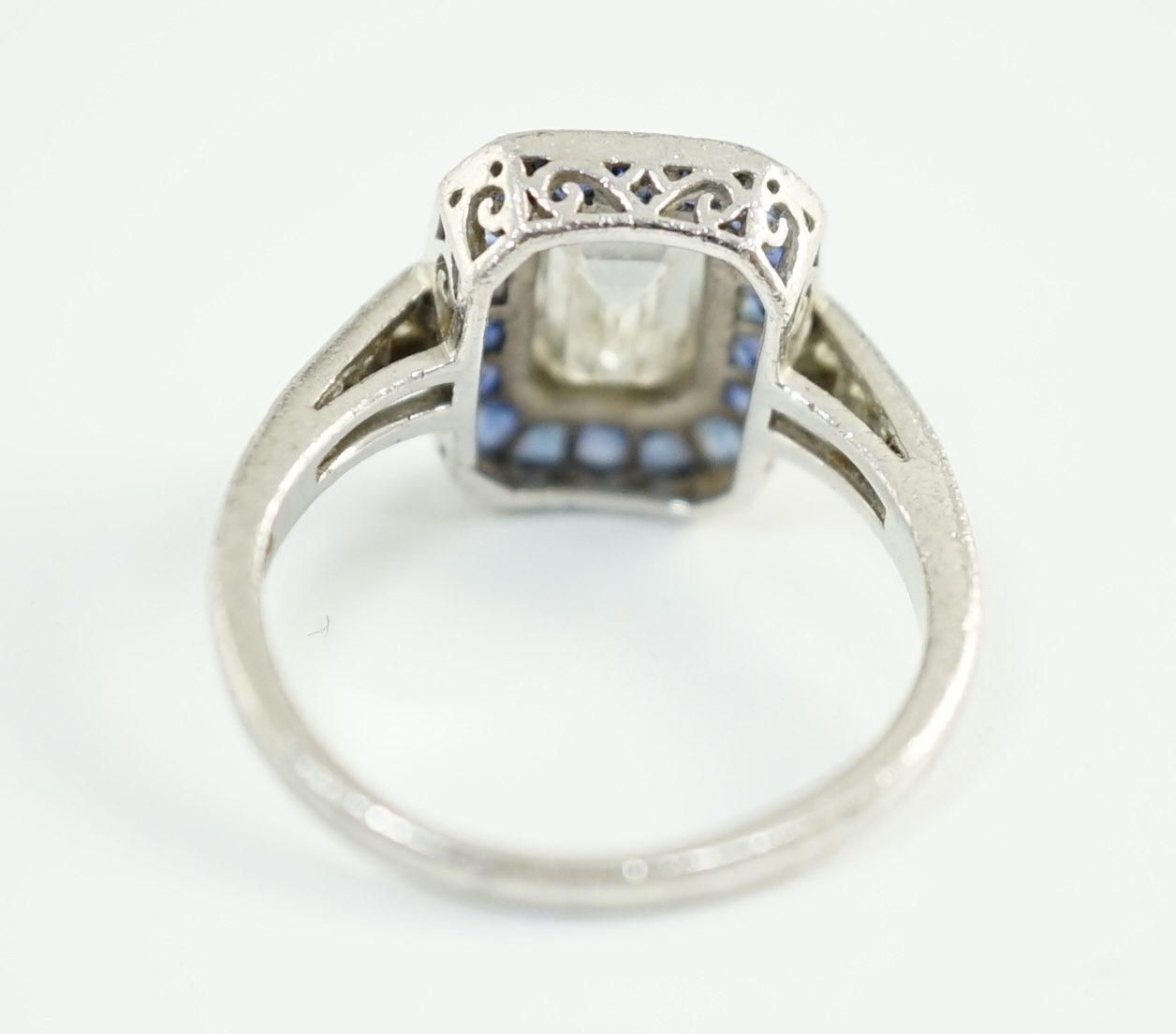 A 1920's platinum and millegrain set single stone emerald cut diamond and sapphire set rectangular cluster ring